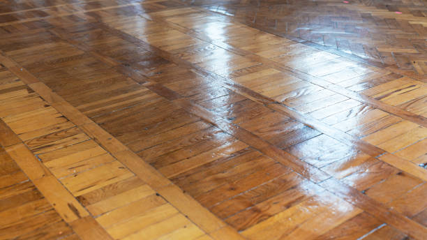 istock Polished wooden parquet floor with visible grain and diagonal patterns reflecting light, creating a rustic yet elegant appearance 2179670938