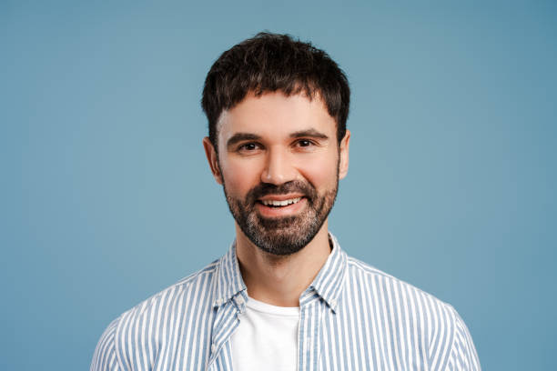 istock Smiling latin man wearing blue shirt looking at camera standing isolated on blue background 2179675904