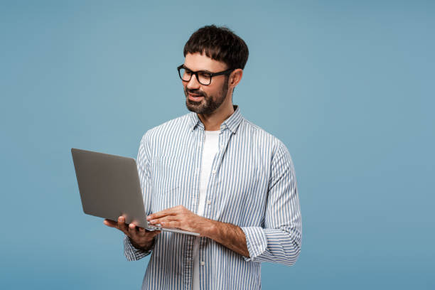 istock Confident bearded man, successful businessman, freelancer wearing stylish eyeglasses using laptop 2179675933