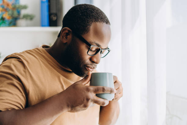 istock Handsome African American man in glasses drinking coffee at home 2179680562