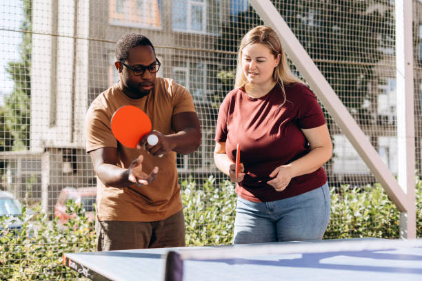 istock Happy people playing table tennis outdoors, having fun 2179680762