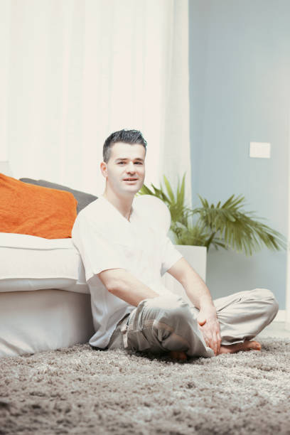 istock Man relaxing on carpet in living room experiencing positive emot 2179680901
