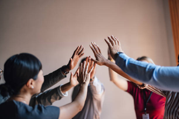 Group of People Celebrating Success with Team High Five