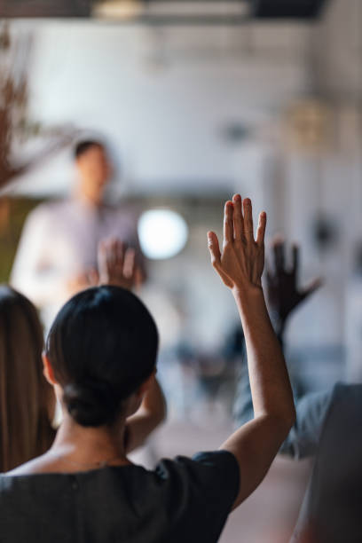 People Raising Hands at a Business Conference Lecture