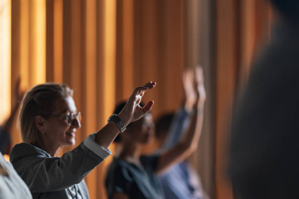 istock Business Conference Attendees Raising Hands in Discussion 2179684465