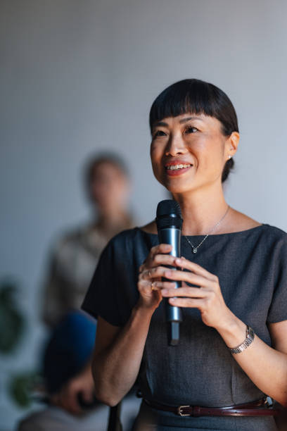 istock Confident Businesswoman Speaking at Conference with Microphone 2179684467