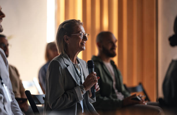 istock Engaged Woman Asking Question at Business Conference 2179684474
