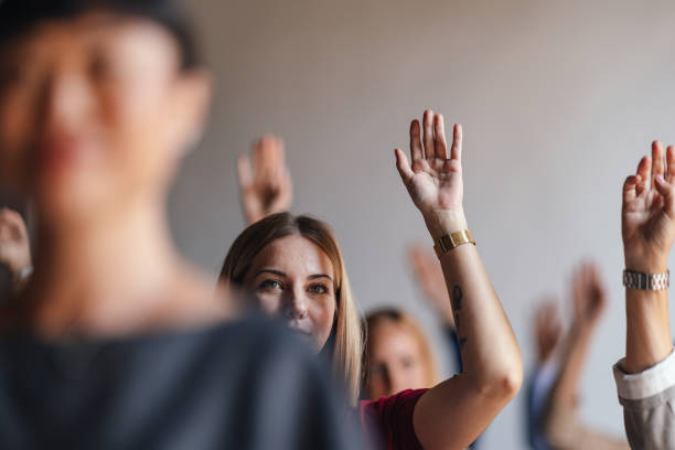 istock Engaged Audience Raising Hands During Interactive Business Seminar 2179684476