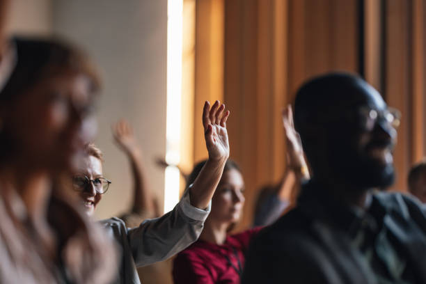 istock Engaged Audience Members Raising Hands During Business Conference 2179684483