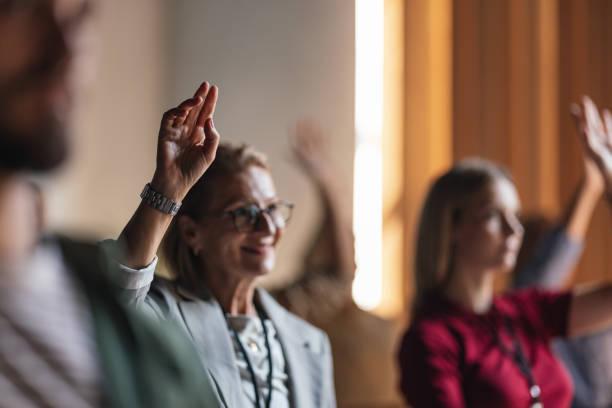 istock Engaged Participants Raising Hands During Business Conference Session 2179684489
