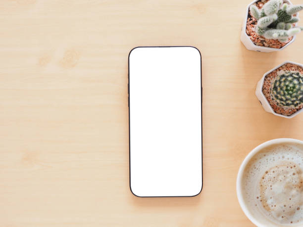 istock Top view, flat lay with copy space. Smartphone mockup screen on light wooden office table, coffee cup and and cuctus. 2179688513
