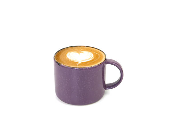 Hot latte coffee with art heart shape in purple ceramic mug isolated on whithe background. space for your text.