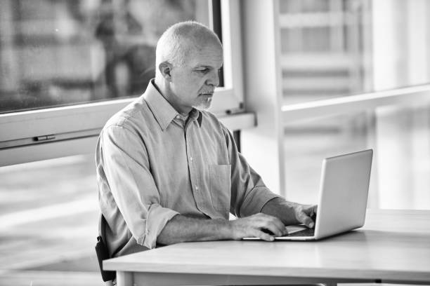 istock Focused mature businessman working on laptop in modern office 2179689290