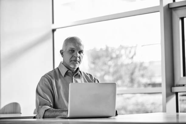 istock Confident mature businessman working on laptop in modern office 2179689373