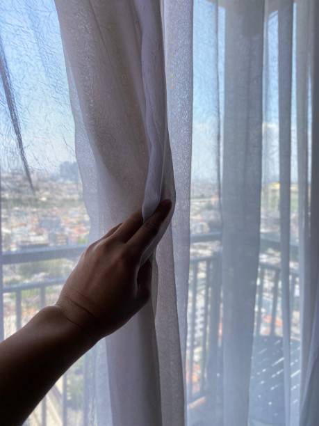 istock Pulling Back the White Curtains, on the Apartment Balcony with City View 2179690630