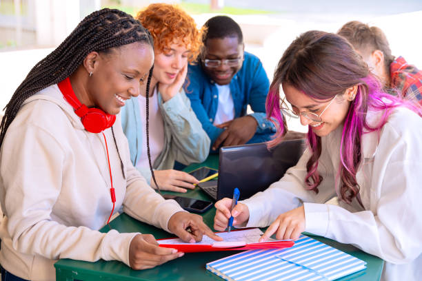 istock A group of students with laptops sit near the campus and communicate. 2179692411