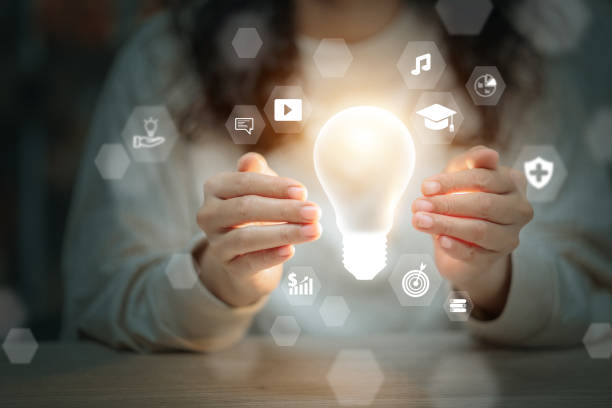 istock A woman is holding a light bulb in her hands, surrounded by various icons 2179693607