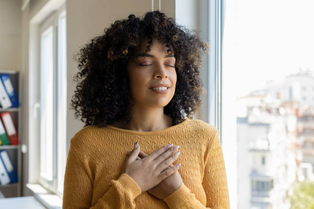 istock Young woman smiling with hands on chest with closed eyes 2179694838