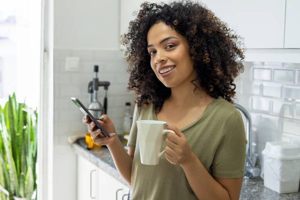 istock Young woman with her phone in kitchen 2179696965