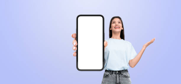 istock A smiling person holds a smartphone with a blank white screen, w 2179700951