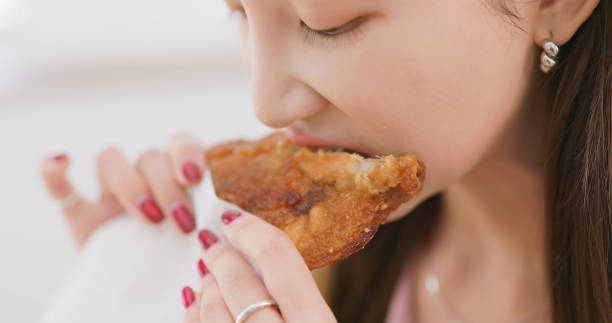 istock woman eat chicken steak home 2179701120