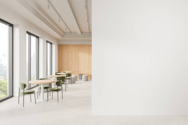 istock Modern cafe interior with wooden tables, green chairs, large windows, and a blank white wall for mockup. Minimalist design. 3D Rendering 2179701203
