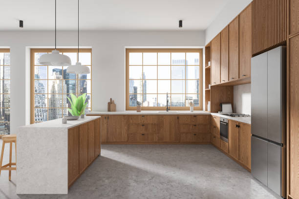 istock Modern kitchen interior featuring wooden cabinets, large windows with a city view, and a central island. Minimalist decor with concrete floor. 3D Rendering. 2179701333