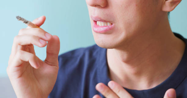 istock asian man smokes discomfort throat 2179701356