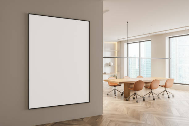 istock A modern office interior with a blank poster on a wall, featuring an open space design. Wooden floor, large windows, and a conference table. 3D Rendering 2179702383