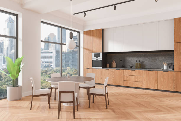 istock A modern kitchen interior featuring wooden cabinets, a round dining table with chairs, and large windows with a cityscape view. Contemporary, showcasing a stylish home decor concept. 3D Rendering 2179702961