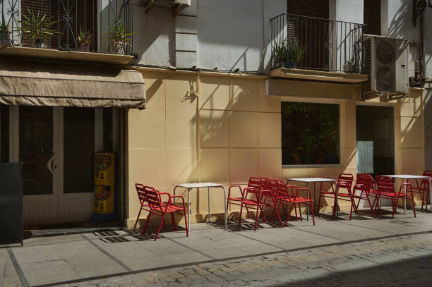 istock Outdoor cafe seating with red chairs under sunlight 2179704379