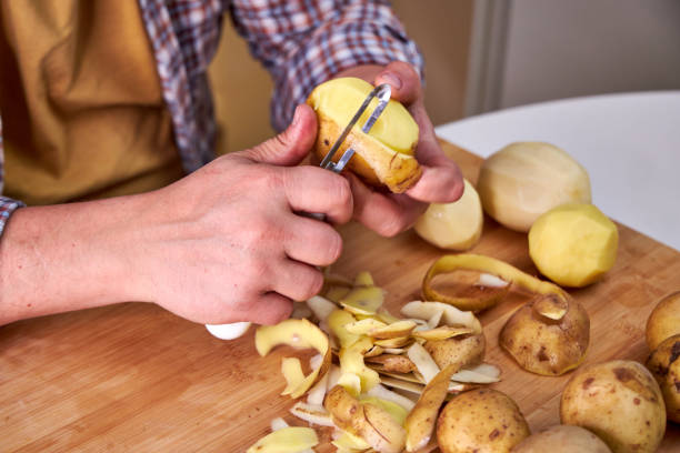 istock man in the kitchen peeling potatoes 2179705313
