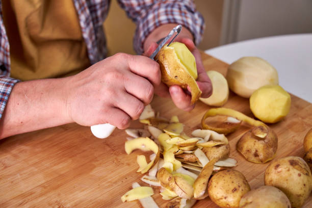 istock man in the kitchen peeling potatoes 2179705314