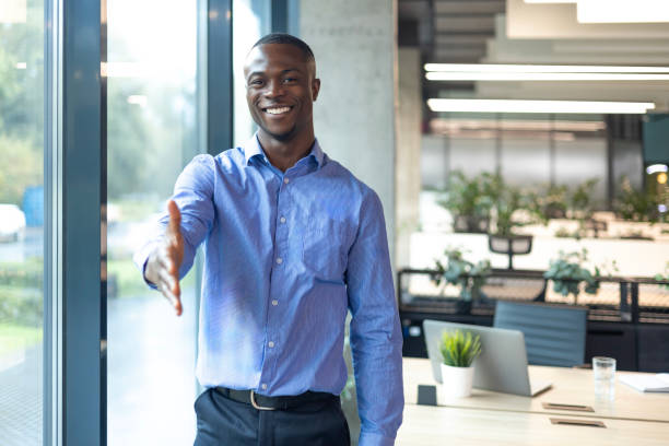 istock Smiling african businessman with open hand ready for handshake 2179707191