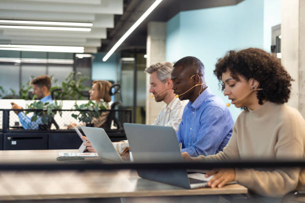 istock Portrait of call center worker accompanied by her team. Smiling customer support operator at work. 2179708637