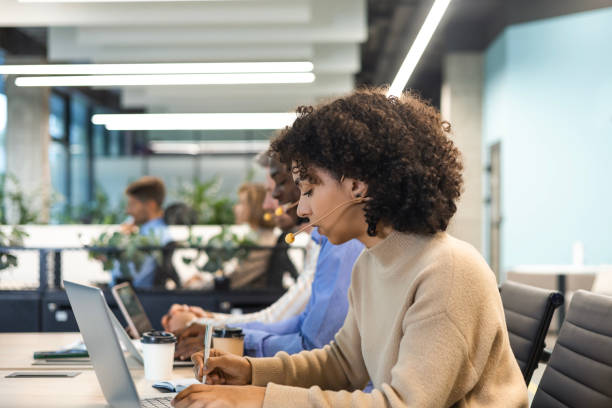 istock Portrait of call center worker accompanied by her team. Smiling customer support operator at work. 2179708678