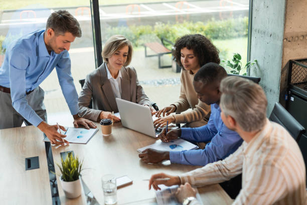 istock Successful businesspeople working in a coworking space working with laptop discussing strategy and business plan in modern office. 2179709758