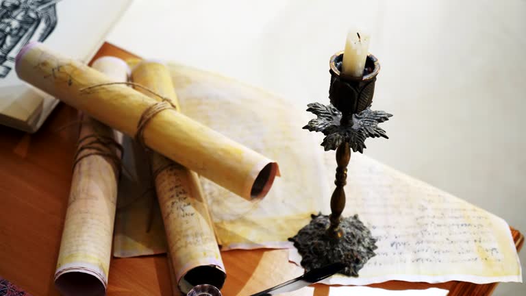 Ancient parchment, bound by time. Aged scrolls and candles. Manuscripts, ancient papers, documents. A historical find, a treasure. The pen, the secret of the ages. Scrolls, a candle, and the scent of aged paper