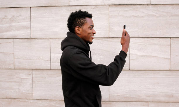 istock Stylish happy African young man taking selfie with phone, black american guy smile using smartphone 2179712913