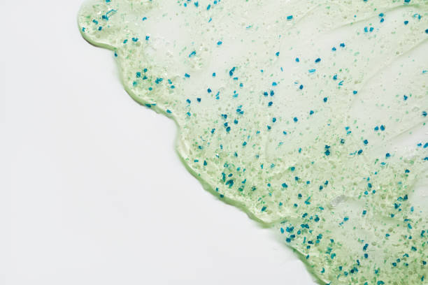 istock Transparent gel texture with blue and green exfoliating particles on white background 2179714446