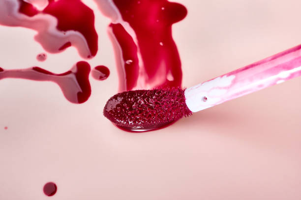 istock Vibrant red lip gloss with brush on pink background 2179714467