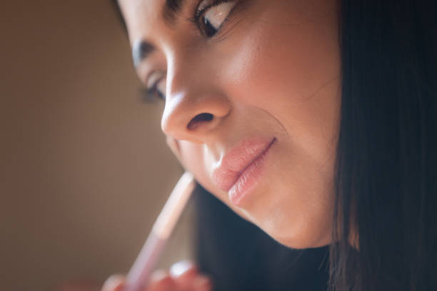 istock Young influencer woman is applying highlighter on her cheeks. 2179728419
