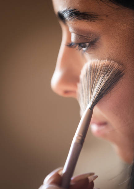 Young woman is applying highlighter and giving techniques to audience while live streaming.