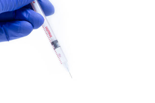 Doctor in blue gloves holding syringe on white background with copy space