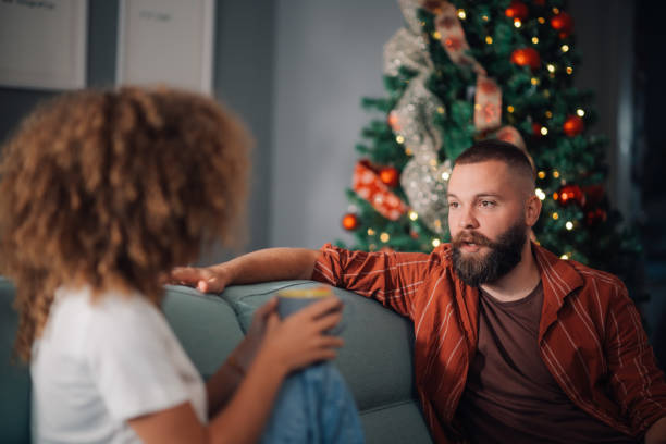 istock Couple relaxing on sofa having intimate conversation during christmas holidays 2179733668