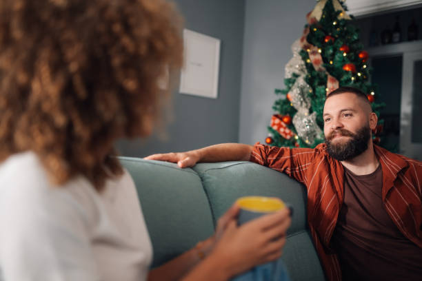 istock Young couple relaxing on sofa by christmas tree 2179733680