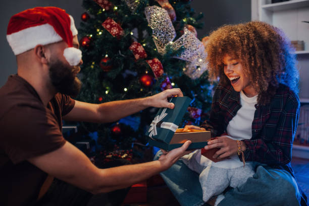 istock Bearded man giving christmas gift to girlfriend surprised by present 2179733785