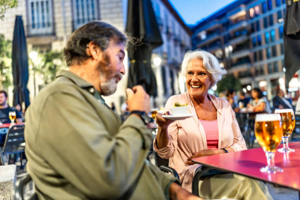 istock Senior man eating tapas next to partner in sidewalk cafeteria 2179735838
