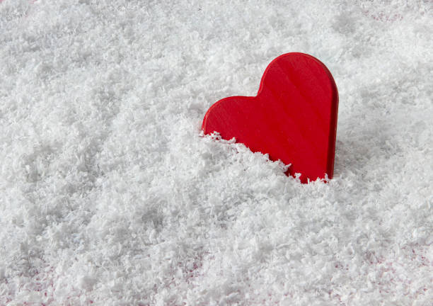 Wooden red heart in pretend snow.