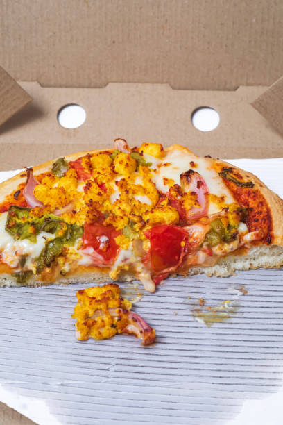 Closeup of leftover pizza in cardboard box on white background. isolated